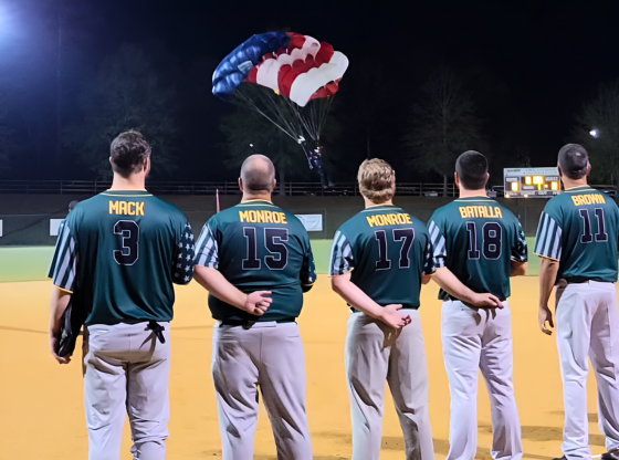 Robbins softball players watch patriotic paratroopers during national anthem